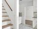 Light-filled entryway with wood stairs, white walls, and views into the kitchen at 509 Hill St, Moncks Corner, SC 29461