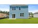 View of the home's light-blue siding, sliding glass door, and compact backyard at 5520 Bowmore Blvd, Ravenel, SC 29470