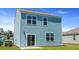 View of the home's light-blue siding, sliding glass door, and compact backyard at 5520 Bowmore Blvd, Ravenel, SC 29470