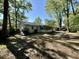 Lush backyard featuring a light-colored home with mature trees providing ample shade and a screened-in porch at 640 Semaht St, Charleston, SC 29412