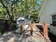 View of the backyard featuring a gated fence and a storage building surrounded by lush greenery and large trees at 640 Semaht St, Charleston, SC 29412