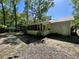 A view of a fenced backyard with a screened-in porch and mature trees surrounding a light-colored home at 640 Semaht St, Charleston, SC 29412