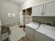 Functional laundry room with overhead cabinets, built-in bench, and modern appliances at 640 Semaht St, Charleston, SC 29412