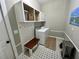 Well-organized laundry room with white cabinetry, built-in bench, and modern patterned tile flooring at 640 Semaht St, Charleston, SC 29412