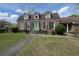 Inviting brick home with dormer windows, black shutters, and a vibrant teal front door at 805 Horne St, Saint George, SC 29477