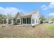 The home's spacious backyard with a sunroom, green grass, landscaping, and great curb appeal at 8739 Grassy Oak Trl, North Charleston, SC 29420