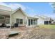 The home's backyard with a sunroom, patio, green grass, landscaping, and great curb appeal at 8739 Grassy Oak Trl, North Charleston, SC 29420