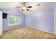 Bright bedroom features a ceiling fan, window with blinds, and a television mounted on the wall at 8739 Grassy Oak Trl, North Charleston, SC 29420