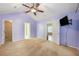 This bedroom offers a ceiling fan, neutral carpet, and multiple doorways leading to other areas of the home at 8739 Grassy Oak Trl, North Charleston, SC 29420
