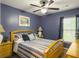 Comfortable bedroom featuring blue walls, a ceiling fan, and a wooden bed frame with striped bedding at 8810 Gilston Ln, North Charleston, SC 29420
