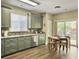 Bright kitchen featuring stainless appliances, sage cabinets, and natural light from the sliding glass door at 8810 Gilston Ln, North Charleston, SC 29420