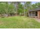 Expansive backyard featuring lush lawn, mature trees, play set, trampoline, and a screened-in porch at 104 Leighton Ct, Summerville, SC 29485
