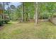Spacious backyard with a wooden fence perimeter provides a private outdoor space and mature trees at 104 Leighton Ct, Summerville, SC 29485
