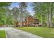 Classic brick home with inviting front porch, mature trees, and a long driveway on a well-manicured lawn at 104 Leighton Ct, Summerville, SC 29485