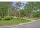 Spacious property featuring a brick home with a covered porch, mature trees, and a long driveway at 104 Leighton Ct, Summerville, SC 29485
