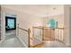 Open hallway with wood railing, safety gate, bright light fixture, and a view to the living room at 104 Leighton Ct, Summerville, SC 29485