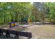 Community playground with various play structures, including swings, slides, and climbing areas, surrounded by trees at 104 Leighton Ct, Summerville, SC 29485