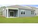 A view of the home's backyard showcases a covered patio, blue siding, and a well-manicured lawn at 1052 Forrest Creek Dr, Summerville, SC 29483