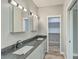 Modern bathroom with double sink vanity, gray countertop, and a walk-in closet at 1224 Midvale Ave, Charleston, SC 29412