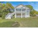 Coastal home with white-painted pilings, garage, and access stairs on the side, blending function with beachside charm at 1224 Midvale Ave, Charleston, SC 29412