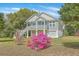 Charming coastal home featuring a garage, stairs to the covered porch, and colorful landscaping at 1224 Midvale Ave, Charleston, SC 29412