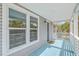 Charming porch with blue floor, white railings, and outdoor lighting adding a touch of coastal elegance at 1224 Midvale Ave, Charleston, SC 29412