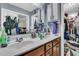 Bathroom with double sinks, white countertops, wooden cabinets, and a view into a cluttered walk in closet at 1252 Wild Goose Trl, Summerville, SC 29483