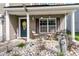 A cozy front porch decorated with outdoor seating, seasonal decor, and stone landscaping at 1252 Wild Goose Trl, Summerville, SC 29483
