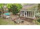 Aerial view of backyard featuring screened porch, fire pit, seating, dining table, and lush landscaping at 181 Commons Way, Goose Creek, SC 29445