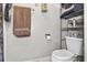 Compact bathroom featuring toilet, towel rack with brown towel, shelving unit, and basic fixtures at 181 Commons Way, Goose Creek, SC 29445