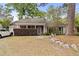 Inviting single-story home with a brick facade, covered porch, and lush greenery in a tranquil setting at 181 Commons Way, Goose Creek, SC 29445