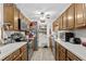 Galley-style kitchen with wood cabinets, neutral countertops, stainless steel appliances, and tile flooring at 181 Commons Way, Goose Creek, SC 29445