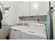 Bright laundry room with white cabinets, utility sink and new washer and dryer at 181 Commons Way, Goose Creek, SC 29445