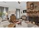Inviting living room with a prominent brick fireplace, ceiling fan, and plush seating for relaxation at 181 Commons Way, Goose Creek, SC 29445