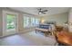 Bright bedroom featuring a ceiling fan, large windows with backyard view, and simple furnishings at 1816 Orangeburg St, North Charleston, SC 29405