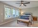 Cozy bedroom with a black metal bed frame, neutral walls, carpet, a ceiling fan, and backyard views at 1816 Orangeburg St, North Charleston, SC 29405
