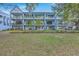 Exterior of a multi-story apartment building with blue siding, well-manicured lawn, and mature trees at 1816 Orangeburg St, North Charleston, SC 29405