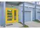 Close-up of a townhome entrance with a bright yellow door, gray siding, and a single-car garage at 1816 Orangeburg St, North Charleston, SC 29405