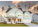 Charming two-story home featuring light blue siding, a welcoming front porch, and an attached two-car garage at 1824 Nola Run, Summerville, SC 29485