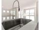 Modern kitchen sink with stainless steel faucet and white marble countertops in a bright, open space at 1824 Nola Run, Summerville, SC 29485