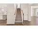 Carpeted staircase with wooden handrail leading to the upper level of a bright, modern home at 1824 Nola Run, Summerville, SC 29485