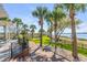 Backyard with mature palm trees, manicured lawn, and view of waterway at 1954 Sandy Point Ln, Mount Pleasant, SC 29466