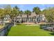 Expansive backyard with lush lawn, mature palm trees, and a charming waterfront home at 1954 Sandy Point Ln, Mount Pleasant, SC 29466