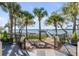 Stunning backyard with palm trees, manicured lawn, and a serene view of the water and private dock at 1954 Sandy Point Ln, Mount Pleasant, SC 29466
