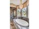 Bathroom featuring a standalone tub, glass shower, large windows, and a decorative chandelier, offering luxury and natural light at 1954 Sandy Point Ln, Mount Pleasant, SC 29466