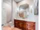 Lovely powder room with wood cabinets, gold fixtures, tile floors and a big mirror at 1954 Sandy Point Ln, Mount Pleasant, SC 29466