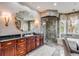 Bright bathroom featuring a framed mirror, wooden vanity, glass shower, tub, and stylish decor in a naturally-lit space at 1954 Sandy Point Ln, Mount Pleasant, SC 29466