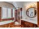 Elegant bathroom featuring a marble-tiled shower, soaking tub, and a stylish vanity with a round mirror at 1954 Sandy Point Ln, Mount Pleasant, SC 29466