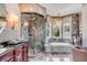 Bathroom featuring a glass shower, soaking tub, vanity, and decorative lighting, complemented by patterned wallpaper at 1954 Sandy Point Ln, Mount Pleasant, SC 29466