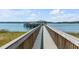 Long wooden dock leading to covered gazebo with boat lift on calm waters, perfect for waterfront living at 1954 Sandy Point Ln, Mount Pleasant, SC 29466